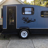 a blue and black trailer parked in front of a house