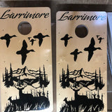 a pair of cornhole game boards with birds flying over a lake