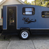 a blue and black trailer parked in front of a house